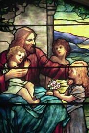 Stained glass representation of Jesus blessing the children by Tiffany Studios